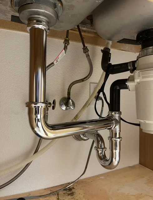 Chrome P-trap and supply lines installed under sink with shut-off valves and flexible connectors