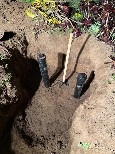 Sewer line installation with black PVC pipe and couplings in excavated trench