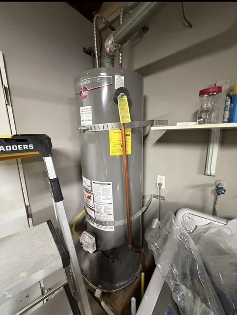 New gas water heater installation with vent piping and safety labels in a San Diego utility room